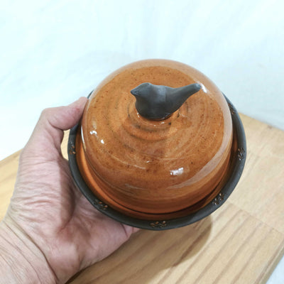 כלי להגשת גבינה או חמאה/בכתום עם ציפור כידית