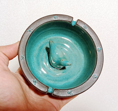 מאפרה כחולה עם ציפור מעוטרת בשוליים